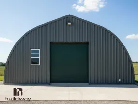 Dark gray Quonset-style steel building by Buildway featuring a large central door and side window, shown under a bright blue sky with scattered clouds.